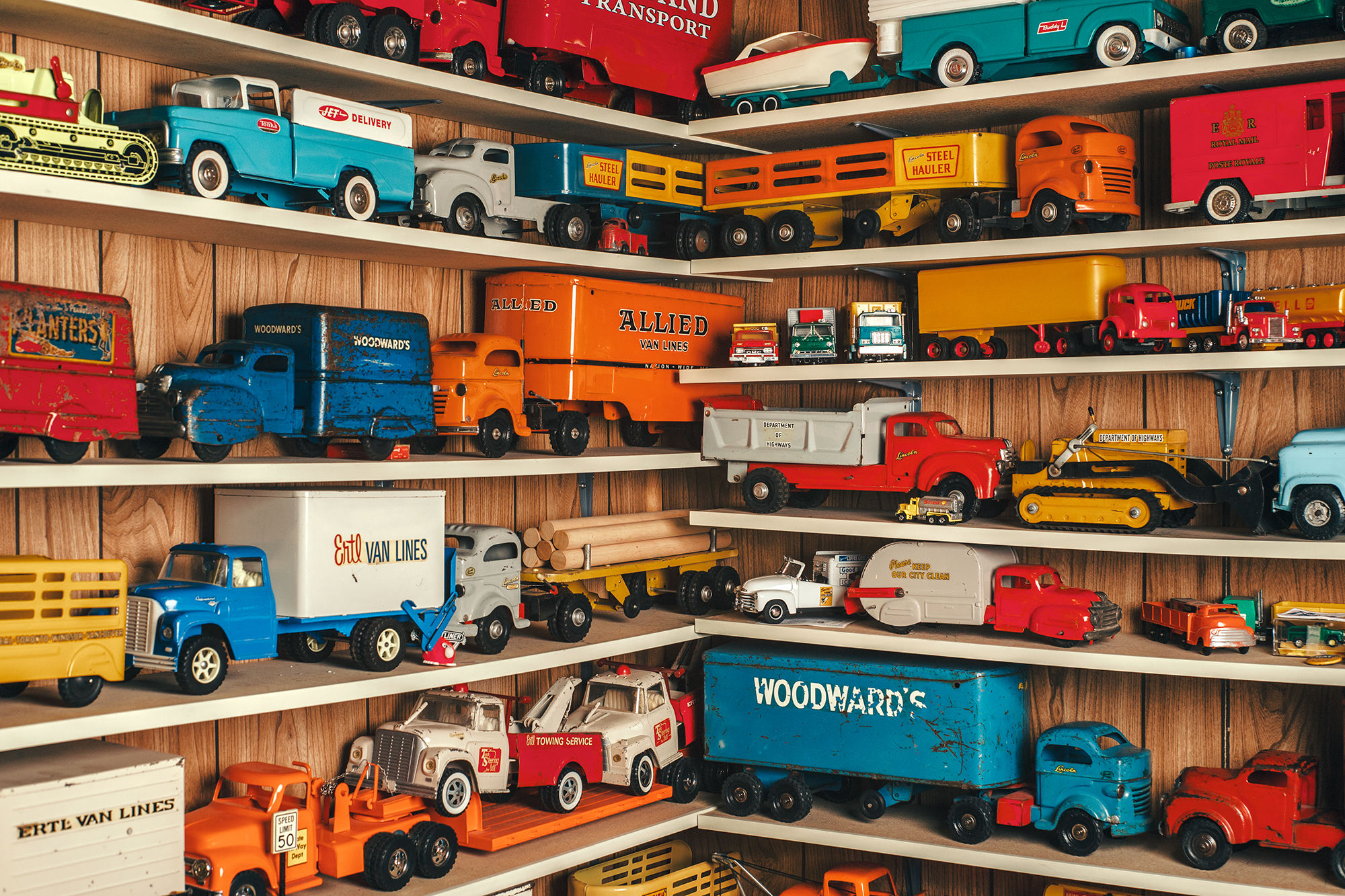 Brightly coloured vintage toy trucks arranged on shelves, example of student photography